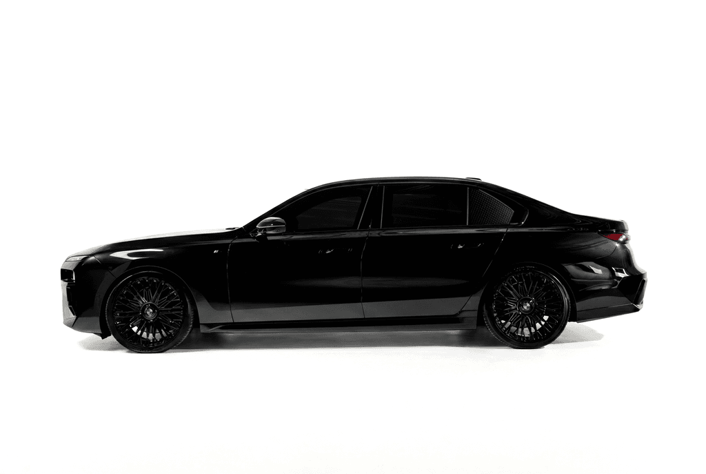 Black BMW 740i on multi-spoke wheels, in side profile against a white studio sweep