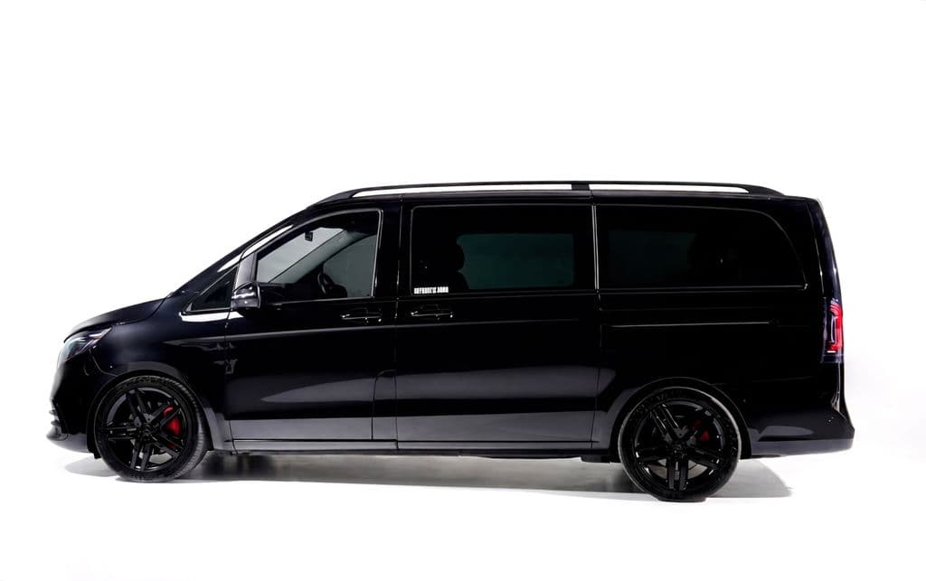 Black Mercedes-Benz V-Class in side profile against a white studio sweep