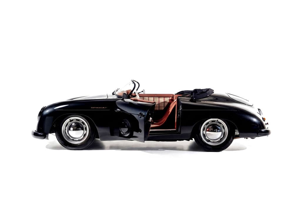 Black Porsche 356 Speedster in side profile against a white studio sweep